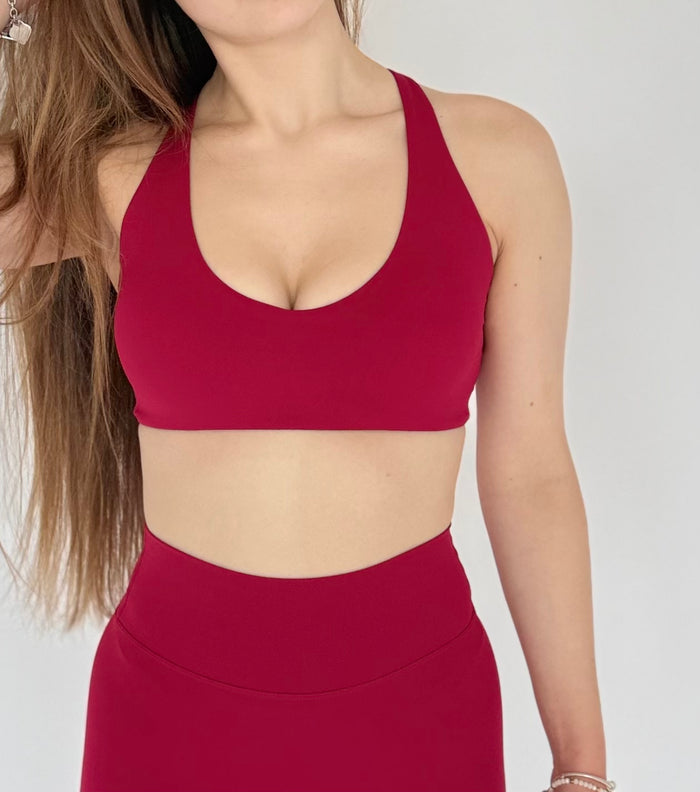 Red sports bra and leggings worn by a person on a plain background