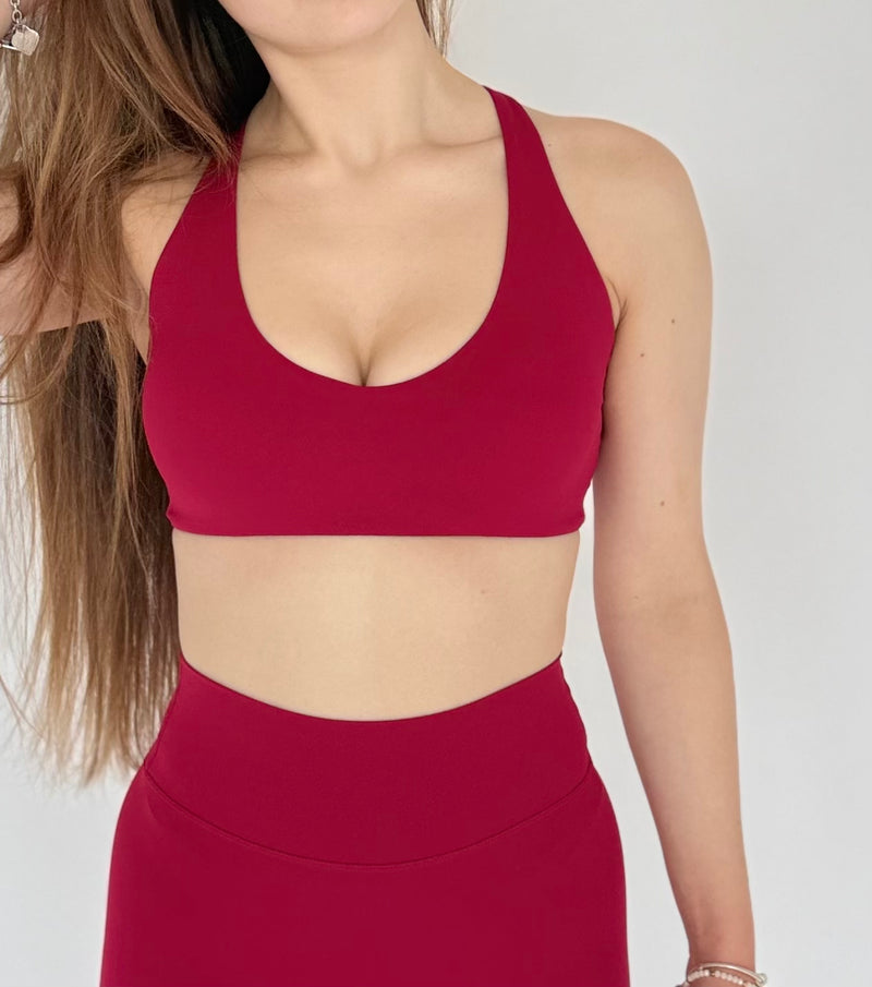 Red sports bra and leggings worn by a person on a plain background