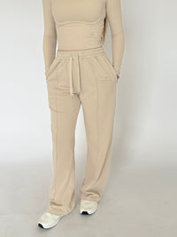 Woman wearing baggy beige joggers with pockets 