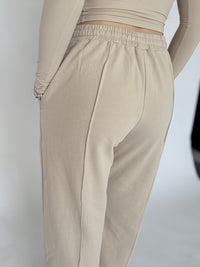 Woman wearing baggy beige joggers with pockets 