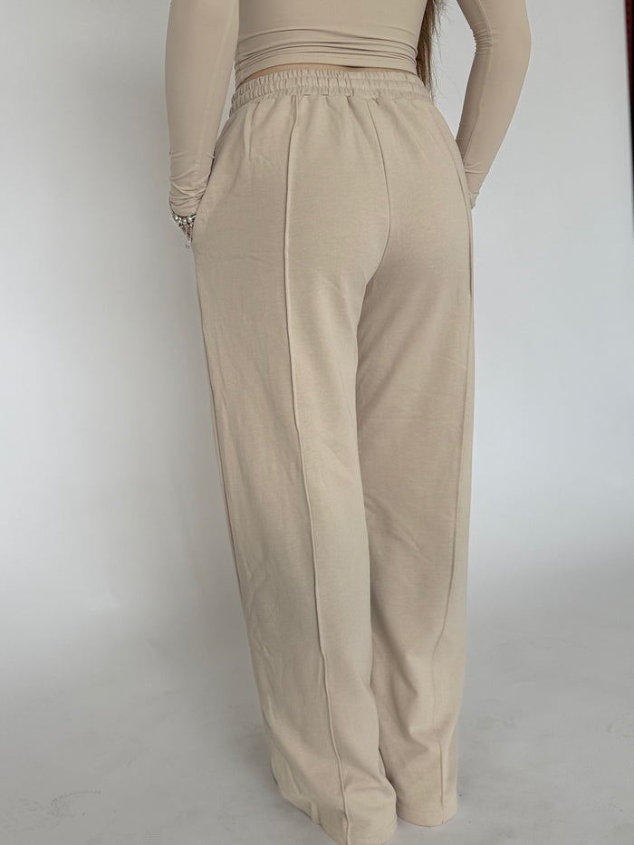 The back of a woman wearing beige long joggers 
