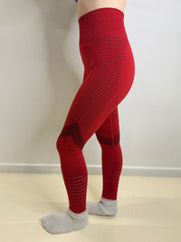 Red leggings worn by a person on a plain background